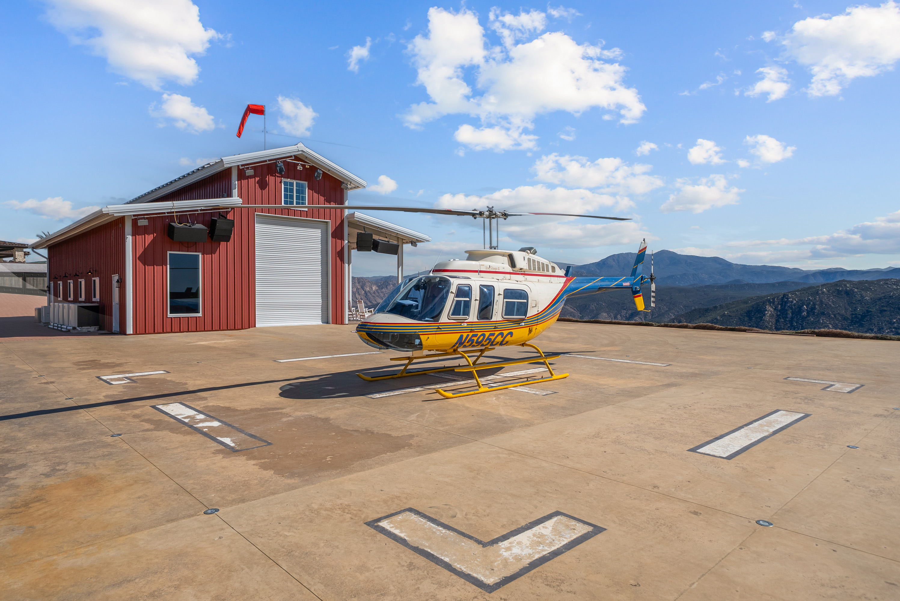 Helipad with helicopter and mountain panorama