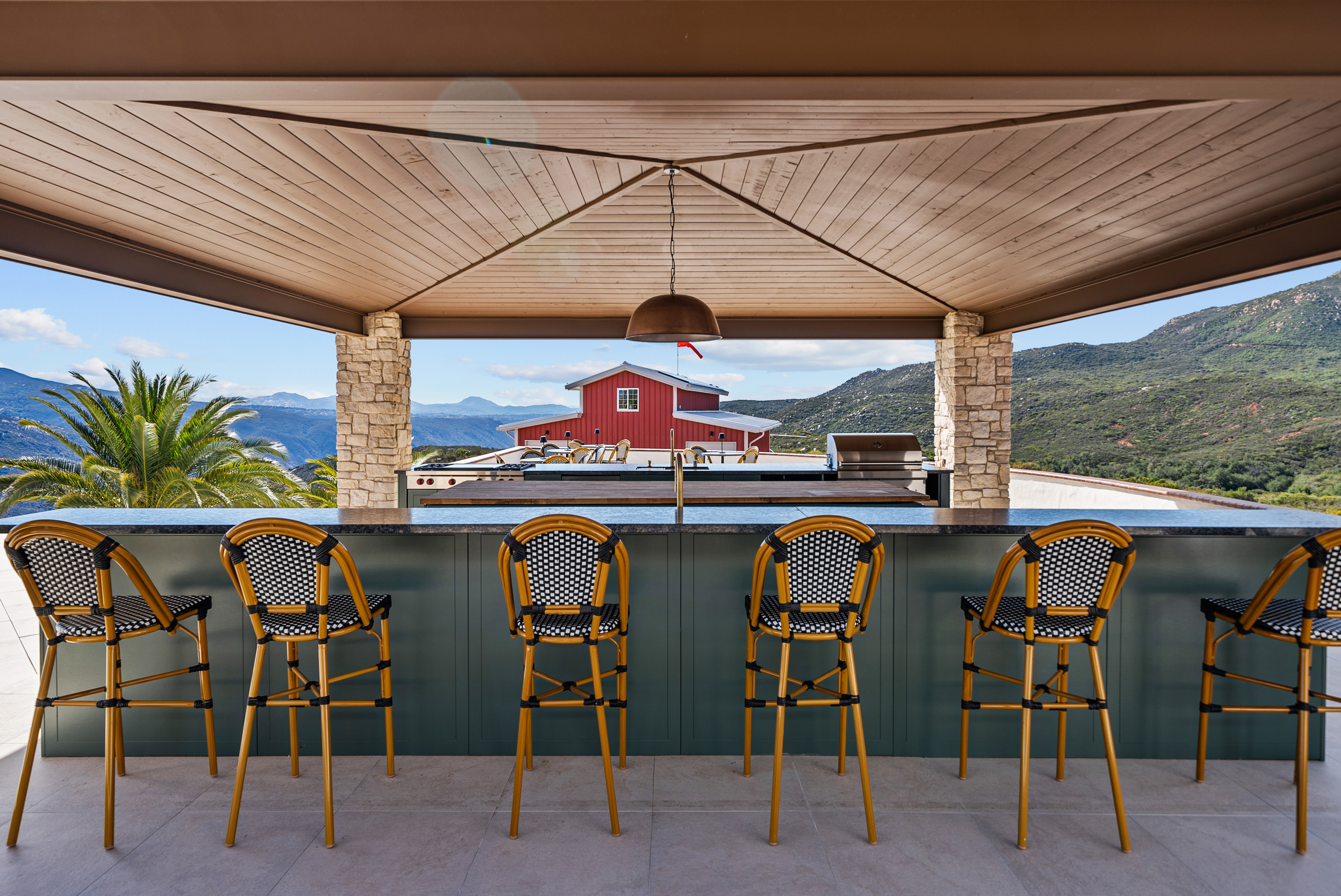 Covered outdoor kitchen and bar with mountain views